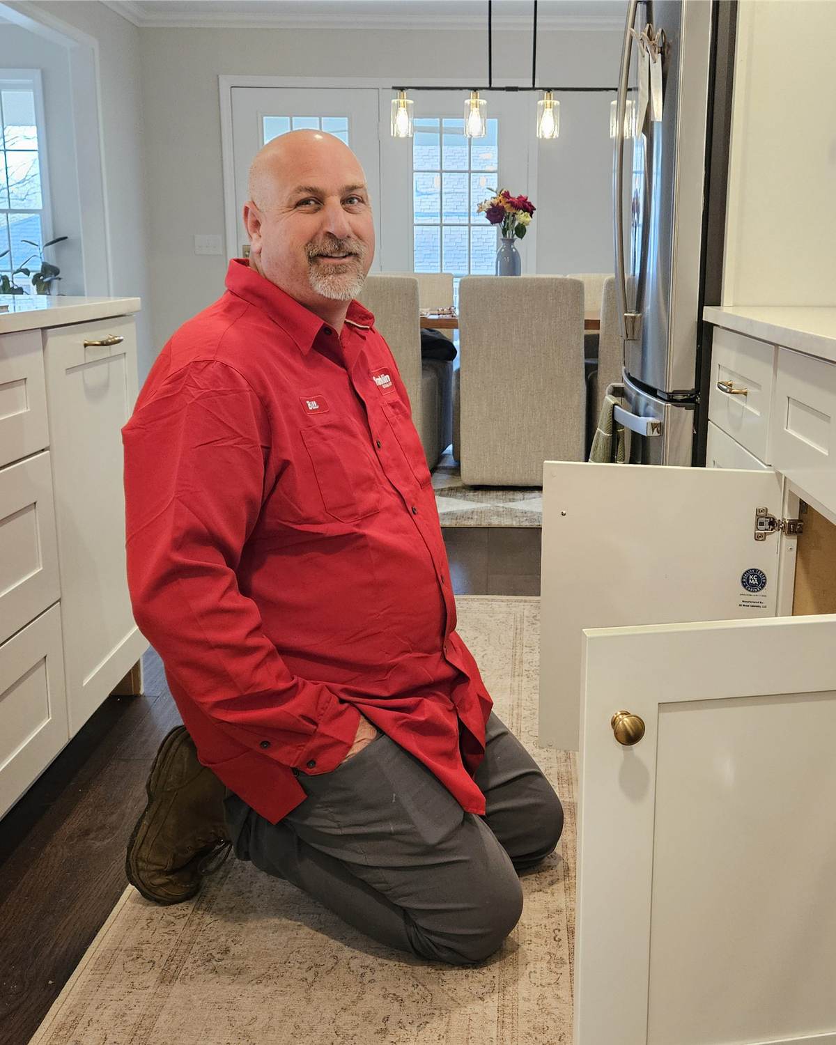 A Franklin plumber repairing a garbage disposal under a kitchen sink in Northwest Arkansas